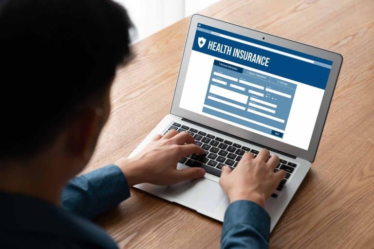Man signing up for health insurance on laptop