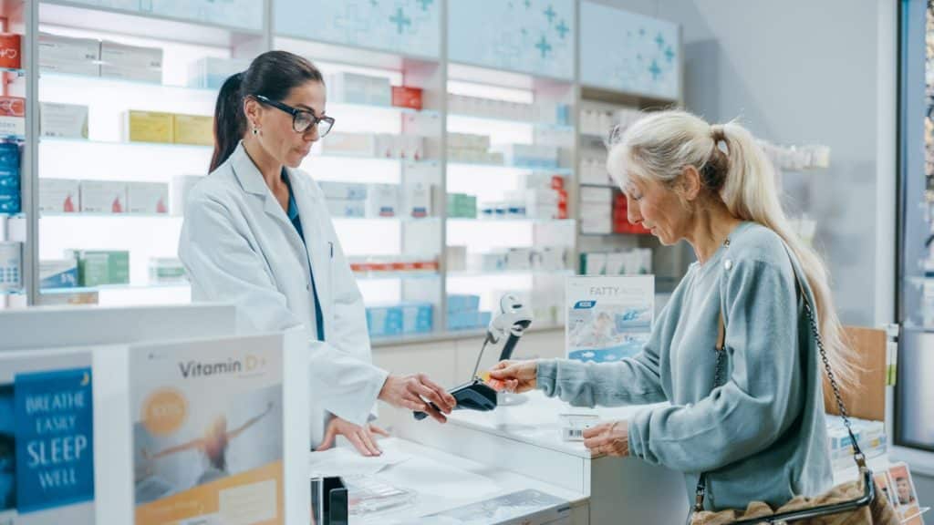 Mature woman paying for medications at the pharmacy